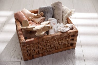 Different baby accessories in basket on floor, closeup