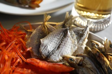 Gri masada farklı kurutulmuş balık ve bira, yakın plan.