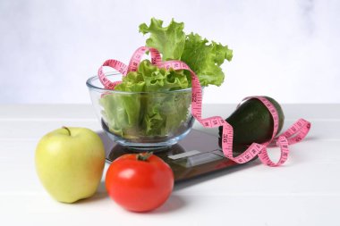 Mutfak pulları, ürünler ve beyaz ahşap masadaki mezuralar.