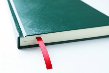 Beyaz masa üzerinde kırmızı kurdele yer imi olan kitap, yakın plan