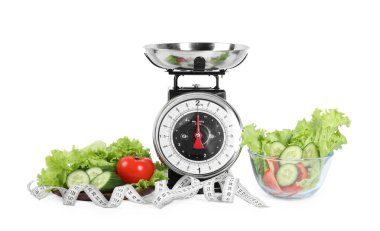 Mutfak pulları, salata, sebzeler ve beyaz arka planda mezura.