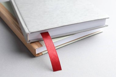 Kırmızı kurdele yer imi ve açık gri masada renkli bir kitap, yakın plan.