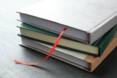 Kırmızı kurdele yer imi ve gri desenli masa üzerindeki renkli kitap, yakın plan.