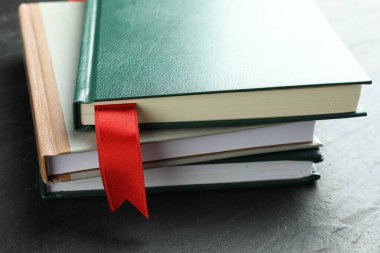 Kırmızı kurdele yer imi ve gri desenli masa üzerindeki renkli kitap, yakın plan.