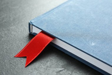 Gri desenli masa üzerinde kırmızı kurdele yer imi olan planlayıcı, yakın plan