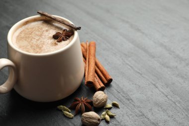 Siyah masada fincanda Aromatik Masala çayı ve baharatlar, yakın plan. Metin için boşluk