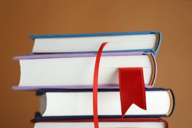 Kahverengi arkaplanda kırmızı kurdele yer imlerine sahip kitaplar, yakın plan