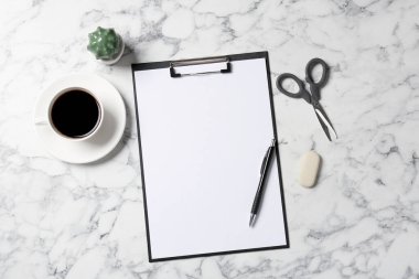 Beyaz mermer zemin üzerinde boş kağıt ve pano ile düz kompozisyon yatıyordu. Metin için boşluk