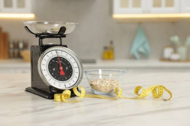 Mutfak pulları, kasedeki yulaf ezmesi ve kapalı alandaki hafif mermer masada mezura.