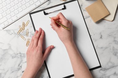 Beyaz mermer masadaki panoya yazı yazan kadın, üst görünüm