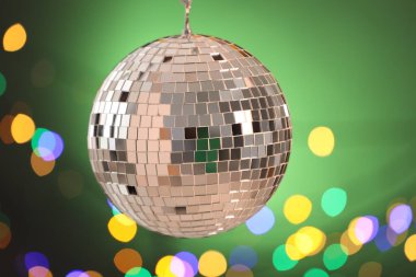 Renk gradyanı arka planında bulanık ışıklarla parlayan disko topu