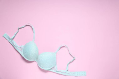 Pembe arka planda dantel bir sütyen, üst manzara. Metin için boşluk