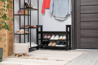 Girişteki raflarda bir sürü farklı ayakkabı var.