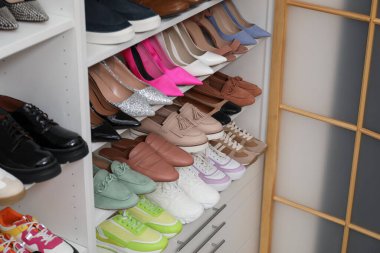 Ayakkabı deposu. Bir sürü farklı ayakkabı çifti olan raf ünitesi kapalı, yakın plan.