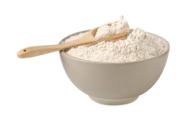 Kahverengi pirinç unu ve kaşık beyaz kasede izole edilmiş.