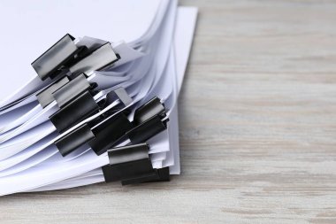 Tahta masanın üzerinde kağıt parçaları olan ataçlar, yakın plan. Metin için boşluk