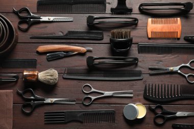 Birçok farklı berber aletleri ahşap masada, düz yatıyordu.