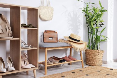 Farklı şık ayakkabılar, hasır şapkalar, poşetler ve ev bitkileriyle ayakta duruyor.