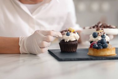 Şekerci, kapkeki çikolatayla süslüyor, yakın plan.