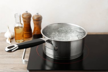 Kaynar suyla tencere ve soba ahşap masa üzerinde beyaz arka plan, yakın çekim