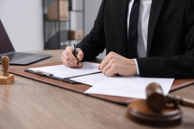 Ofisteki ahşap masada noter imzalı belge, yakın plan.