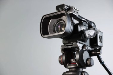 Açık gri arka planda modern video kamera, yakın plan. Metin için boşluk