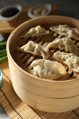 Bambu buharlı tencerede kaynamış gyoza (hamur tatlısı), yakın plan.