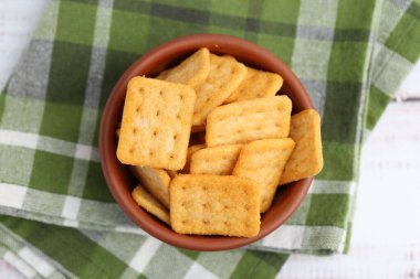 Beyaz ahşap masada leziz tuzlu krakerler.