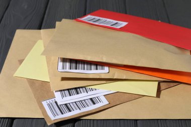 Gri ahşap masadaki farklı zarflar, yakın plan. Postane