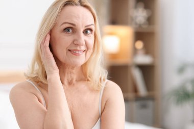 Evde gülümseyen orta yaşlı bir kadının portresi. Metin için boşluk