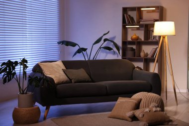 Rahat kanepesi ve ahşap raf ünitesi olan şık bir oturma odası. İç tasarım