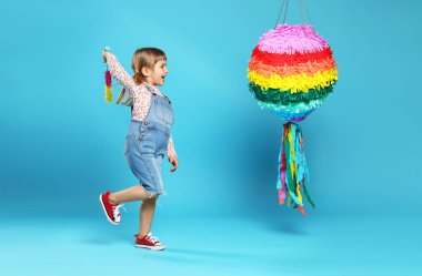 Parlak pinyatalı ve açık mavi arka planda mutlu bir kız.