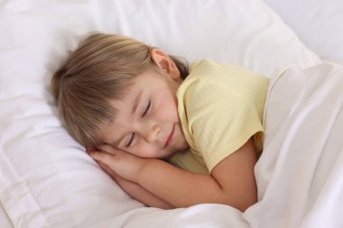 Yatma vakti. Yatakta uyuyan tatlı küçük kız.