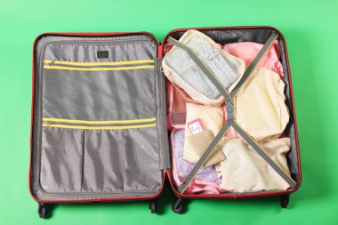 Elbiseli bavul, pasaport ve açık yeşil arka planda bilet, üst manzara