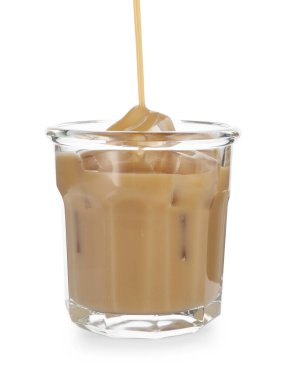 Kremalı kahve likörünü beyaza izole edilmiş bardağa döküyorum.