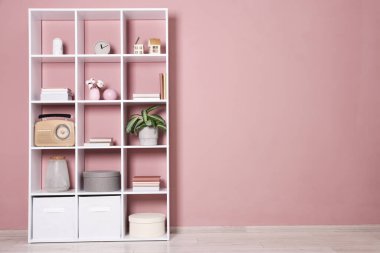 İçeride pembe duvarın yanında dekorasyonu olan raf ünitesi. Metin için boşluk