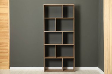 Boş raf ünitesi ve kapalı alanda gri duvarın yanında katlanan ekran