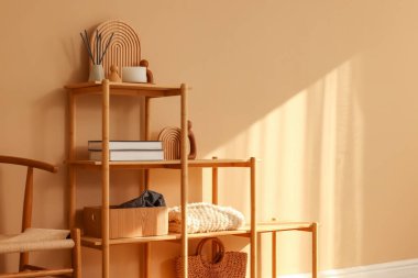 Shelving unit with decor near beige wall indoors