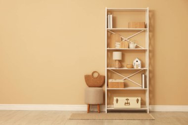 Dekor, dışkı ve hasır çantalı raf ünitesi, kapalı alanda bej duvar, metin için boşluk