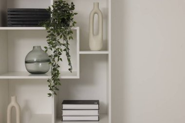 Beyaz duvarın yanında dekorlu raf ünitesi, metin için boşluk