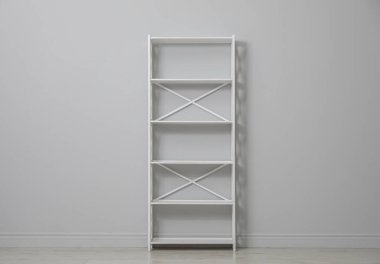 Açık gri duvarın yanındaki boş raf ünitesi