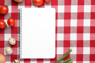 Boş tarif kitabı ve kareli masa örtüsü üzerindeki ürünler, düz yatak. Metin için boşluk