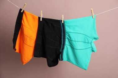 Açık kahverengi arka planda çamaşır ipinde rahat erkek iç çamaşırları