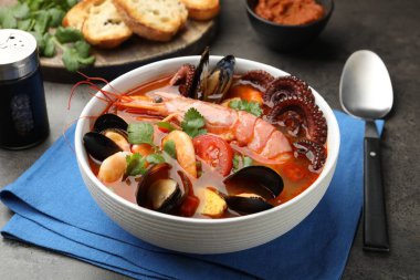 Gri desenli masada servis edilen lezzetli deniz ürünleri çorbası, yakın plan.