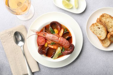 Açık gri masada servis edilen lezzetli deniz ürünleri çorbası.