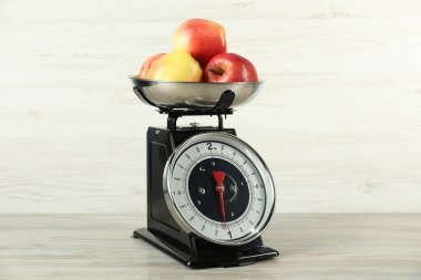 Retro mechanical kitchen scale with apples on wooden table