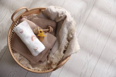 Yerdeki sepetin içinde farklı bebek aksesuarları, üst manzara. Metin için boşluk