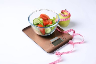 Beyaz üzerine izole edilmiş salata, elma ve mezura ile elektronik mutfak terazileri.