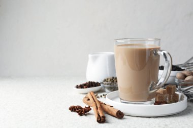 Cam bardakta Aromatik Masala çayı, beyaz desenli masa üzerinde baharatlar ve kahverengi şeker, metin için boşluk
