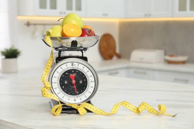 Mutfak terazileri meyve ve mezura içerideki hafif mermer masada. Metin için boşluk